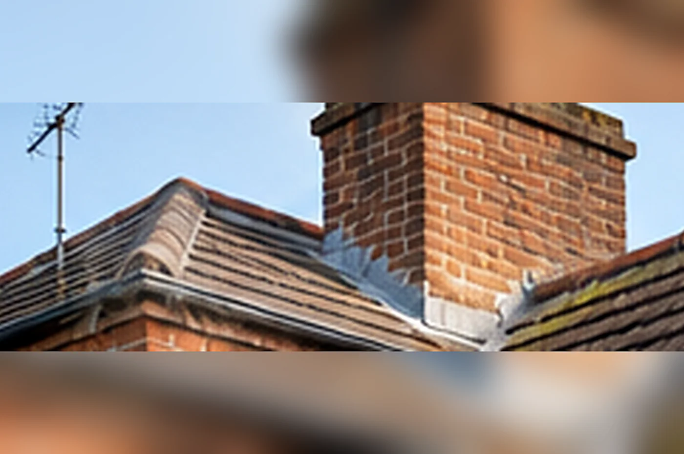 shared chimney stack - brick chimney stack rising above a slate house roof