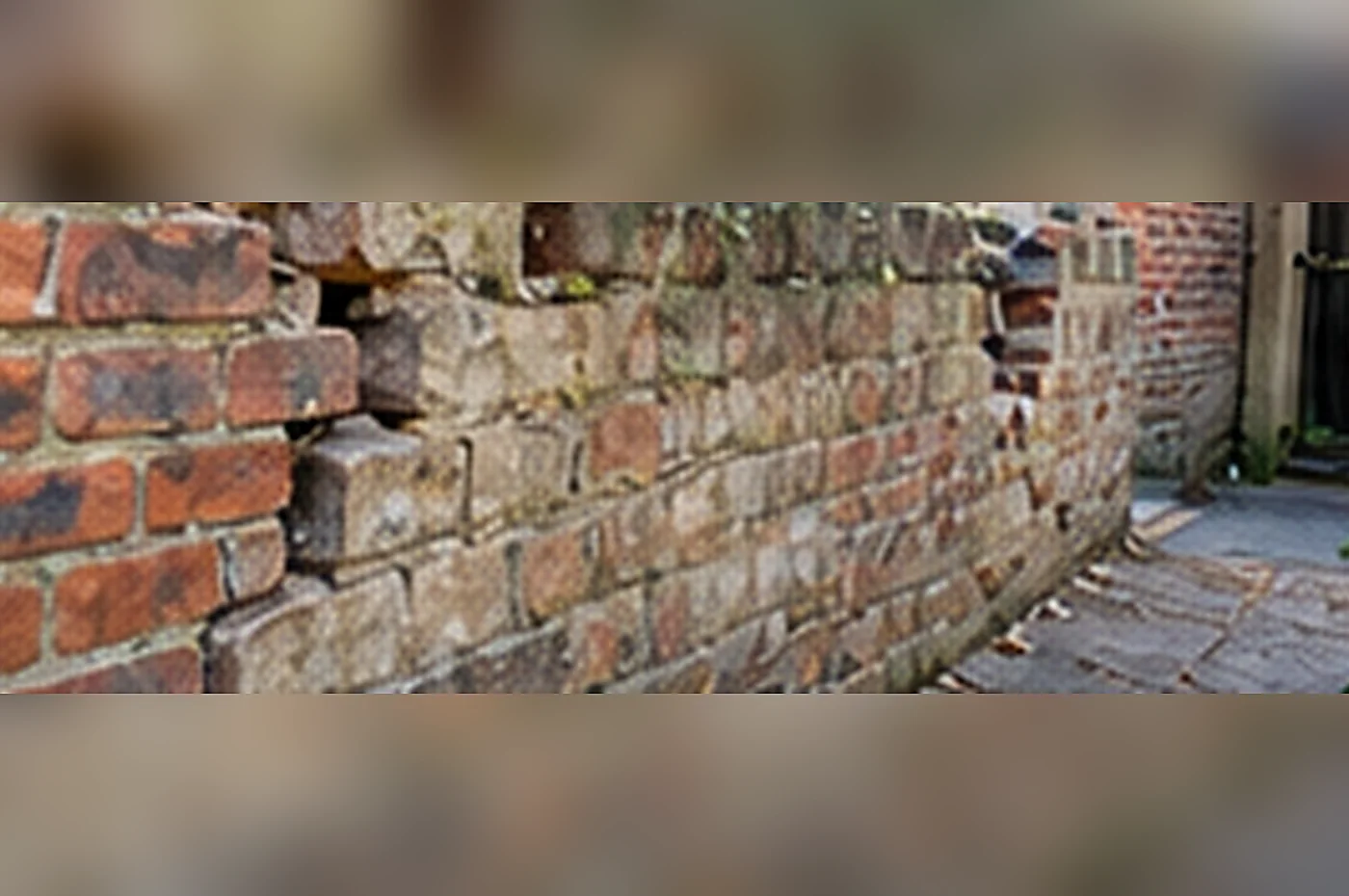 boundary wall ownership - aged brick garden wall showing damaged masonry requiring repair