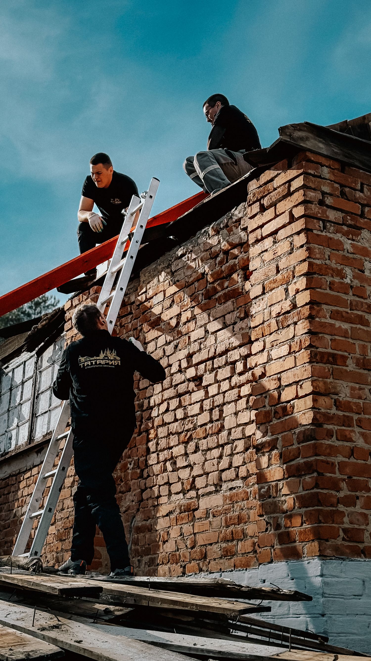 boundary wall rules - builders repairing the brickwork of an outdoor masonry wall