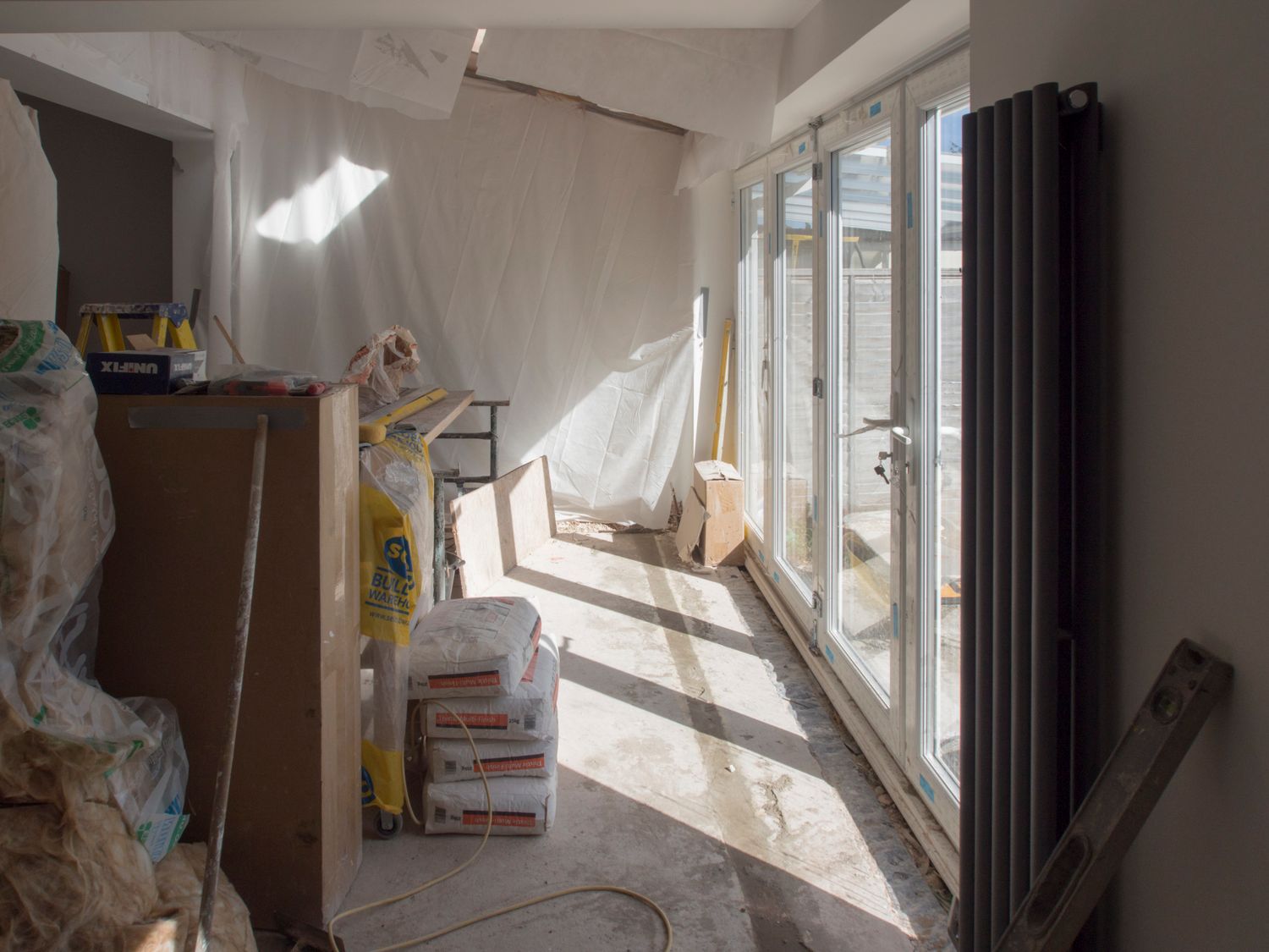 home renovation planning - natural light entering a partly renovated room with tools and exposed finishes
